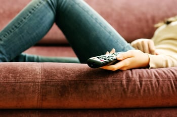 Closeup image of a female hand holding remote control.jpeg