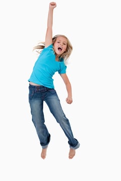 Portrait of a cheerful girl jumping against a white background.jpeg