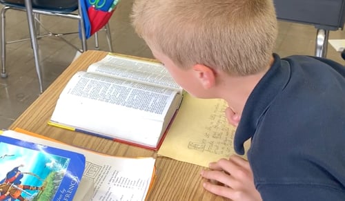 boy writing scripture