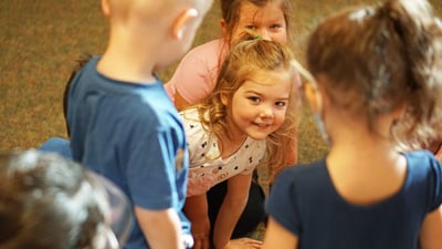 girl-peeking-through-group-smiling