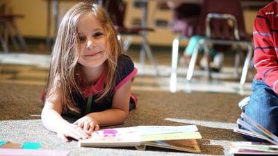 girl-reading-on-floor-smiling