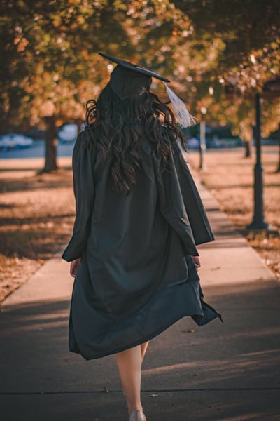 graduate walking down sidewalk