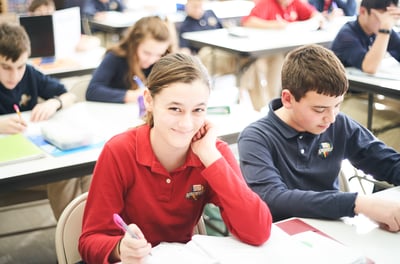 secondary student smiling at desk